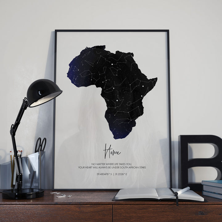 framed African star map in black frame on desk 